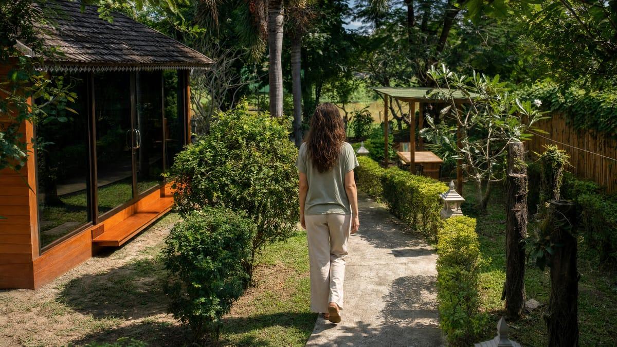 A woman walking the garden path in the grounds of Jintara benzodiazepine rehab in Chiang Mai