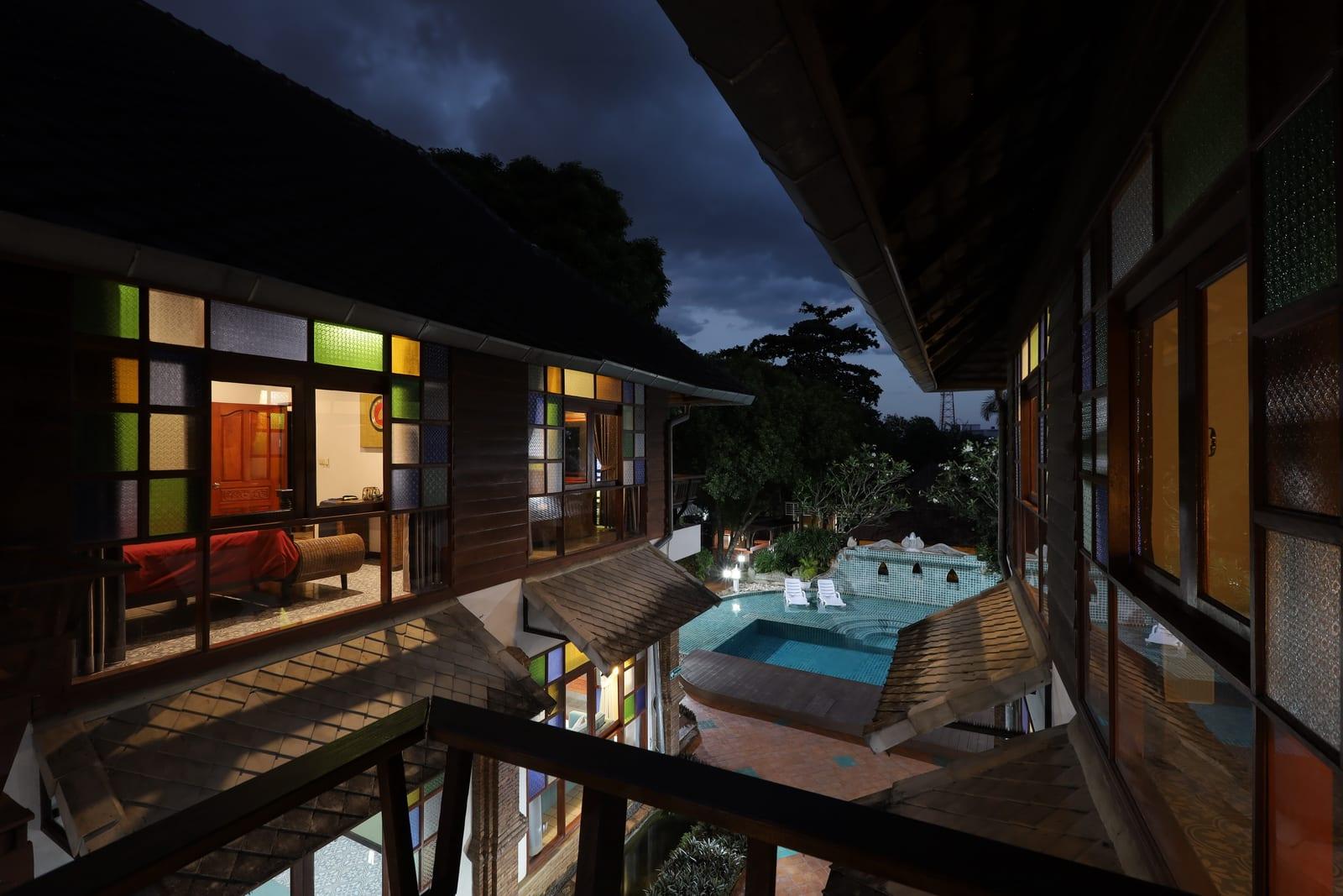 Night aerial view of Jintara Rehab compound with lit stained glass windows and central pool
