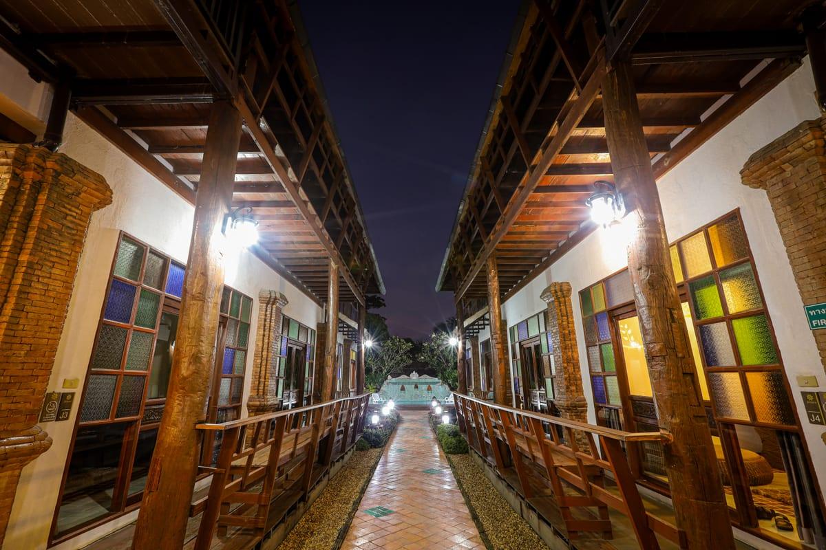 Night view of lit central walkway between Lanna-style buildings at Jintara Rehab Chiang Mai