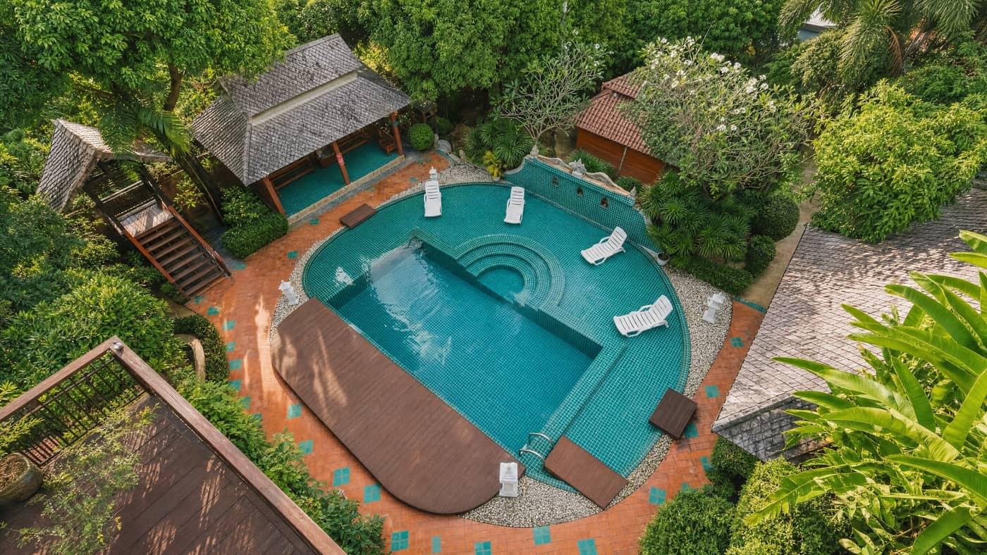 Aerial view of the pool courtyard with teak salas and tropical gardens at Jintara Rehab, Chiang Mai