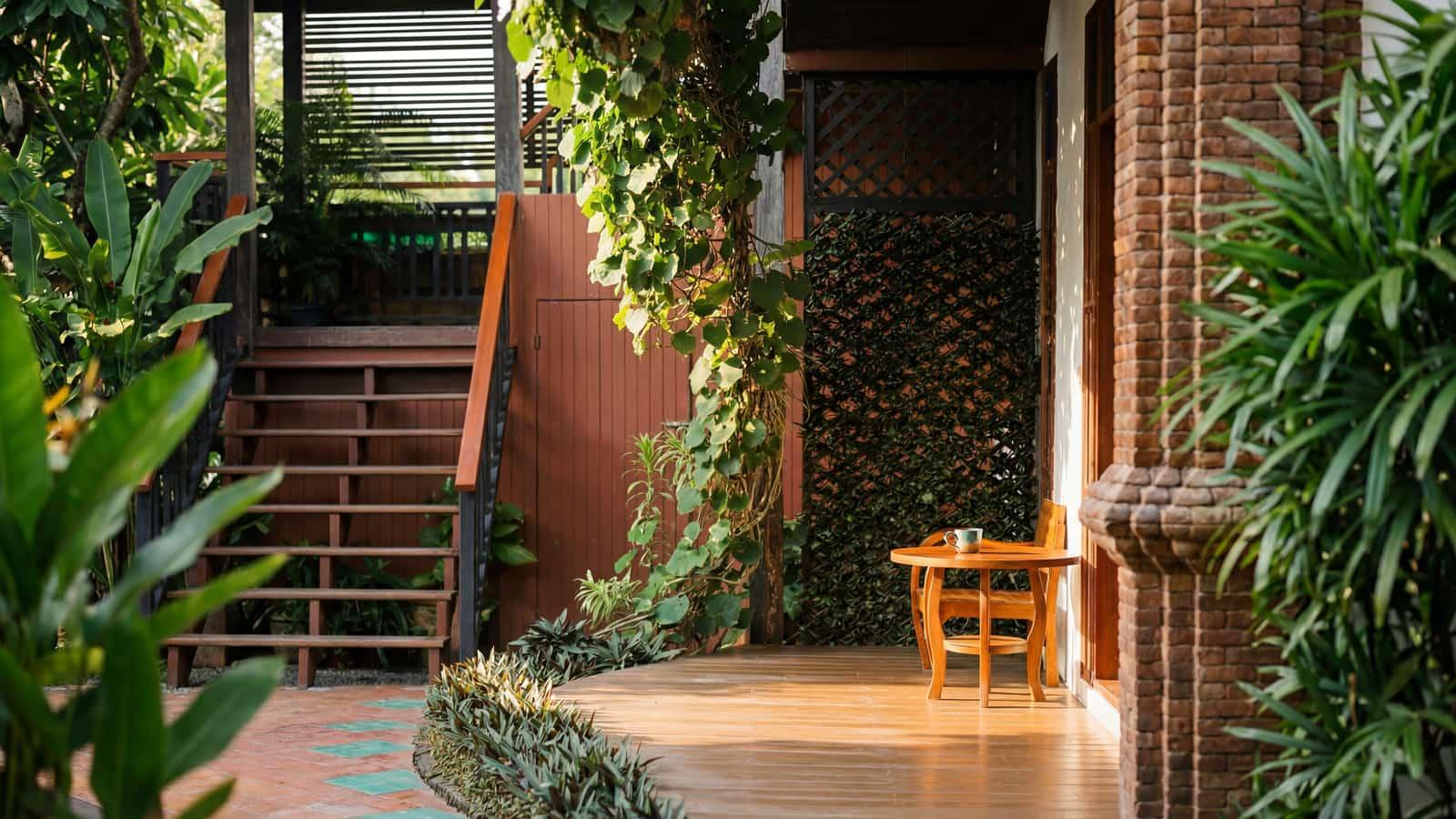 Lush tropical garden and Lanna-style teak buildings at the Jintara Rehab compound in Chiang Mai