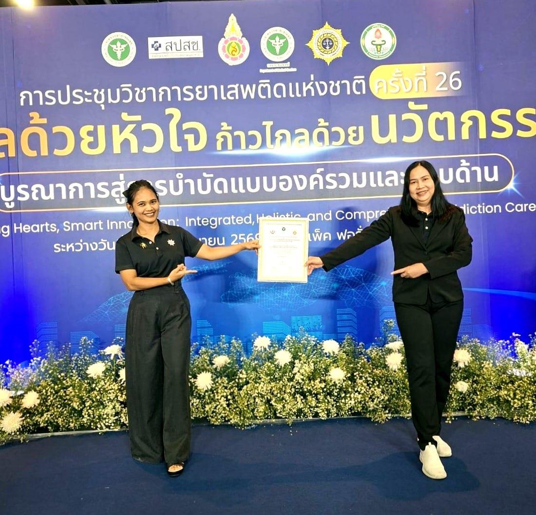 Two members of the Jintara team holding the national accreditation certificate at the 26th National Drug Dependence Academic Conference in Bangkok