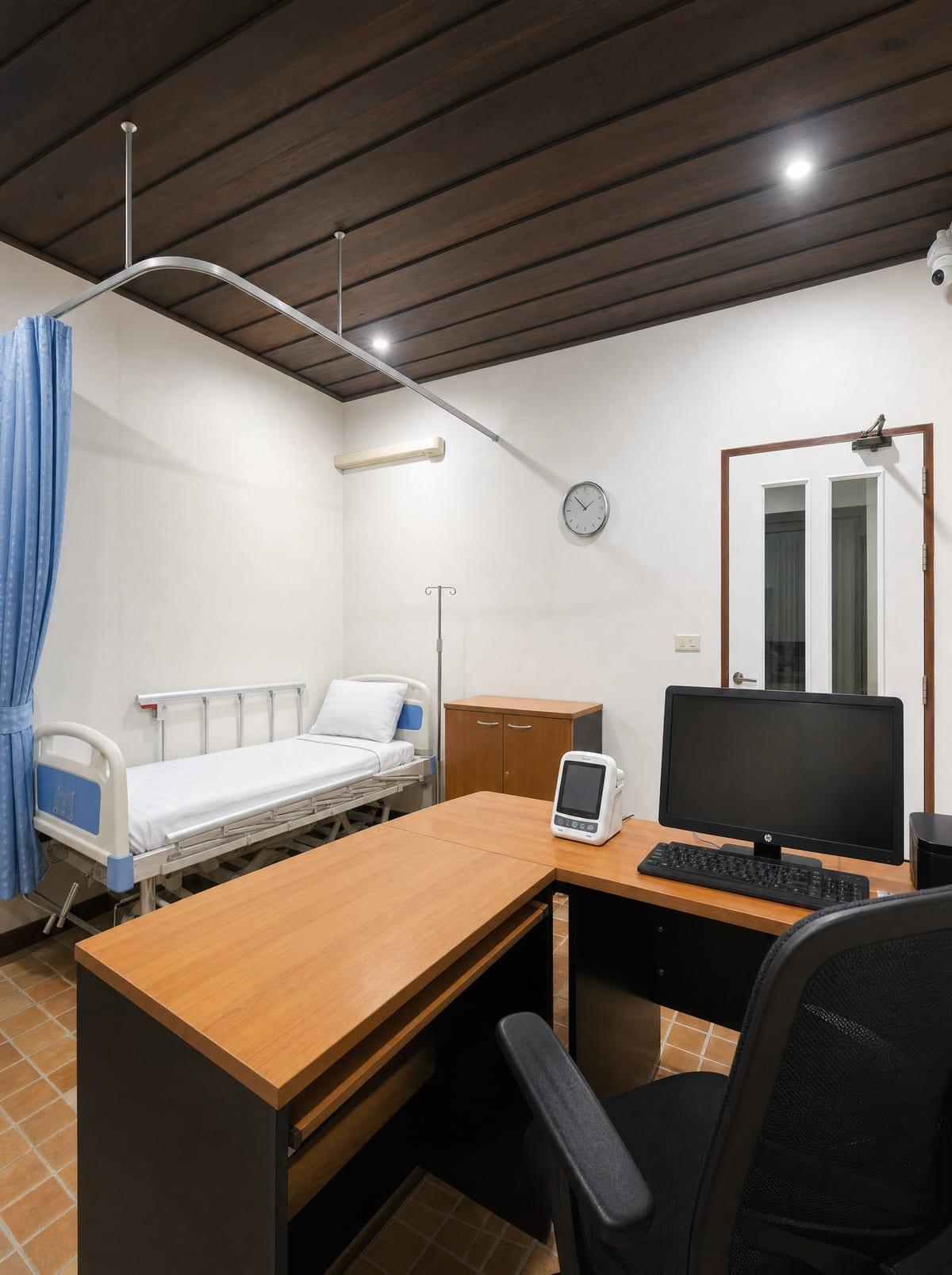 Clinical assessment room with hospital bed and medical workstation at Jintara Rehab Chiang Mai
