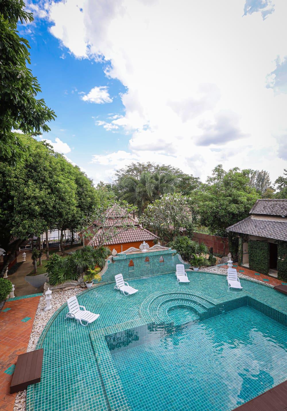 Elevated balcony view of Jintara Rehab teal mosaic pool with sun loungers and tropical gardens Chiang Mai