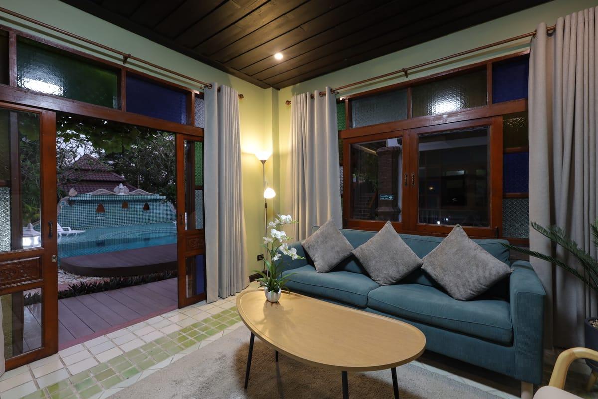 Interior lounge at Jintara Rehab Chiang Mai with pool doors open in the evening