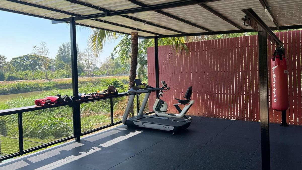 Jintara's real covered gym with a red boxing bag suspended from the steel frame
