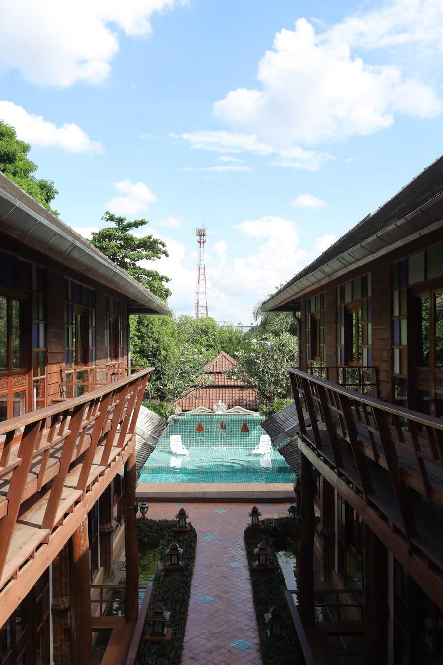 Overhead view of Jintara Rehab compound with teal pool, Lanna-style buildings, and tropical trees