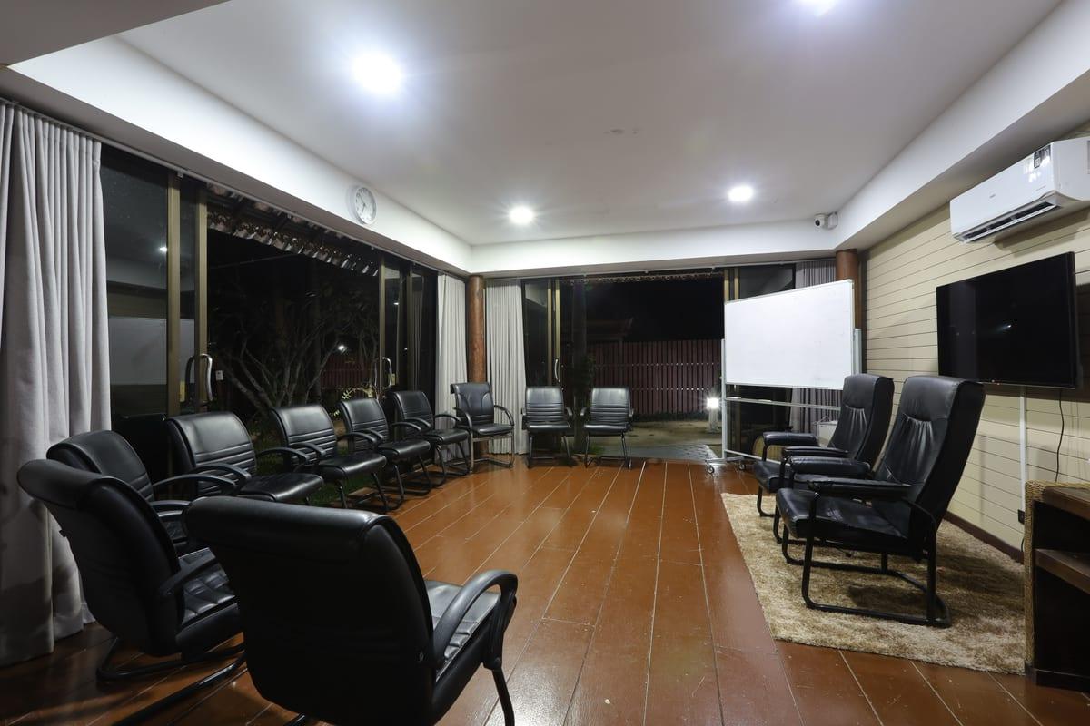 Group therapy room at Jintara Rehab with chairs in a circle and glass doors to tropical garden