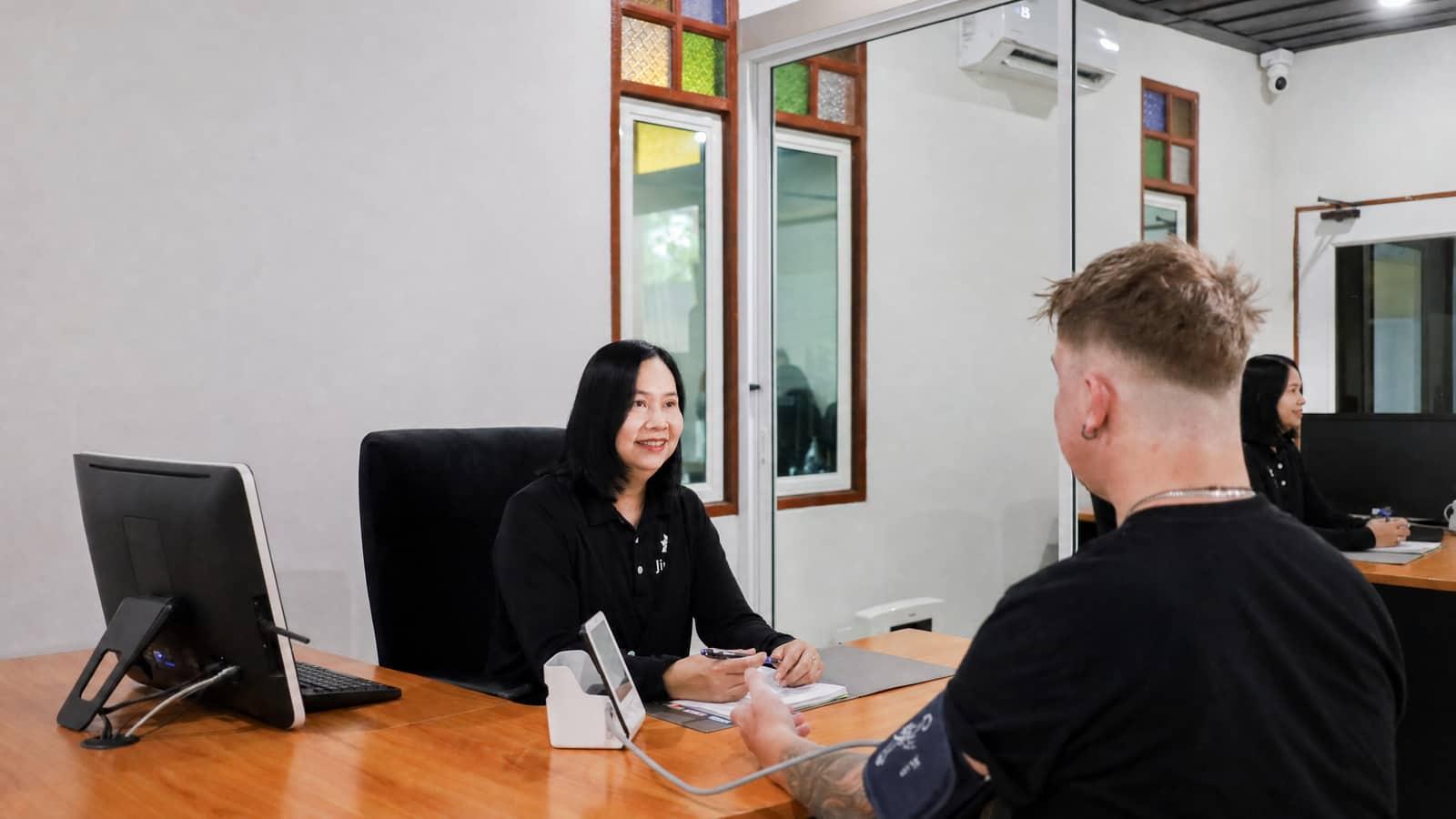 Clinical staff member in consultation with a client at Jintara Rehab medical detox facility Chiang Mai