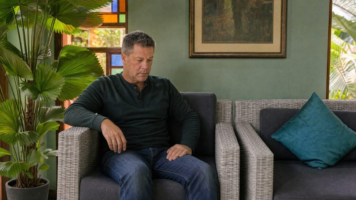 Man sitting in quiet reflection in a Jintara lounge, carrying co-occurring bipolar disorder and addiction