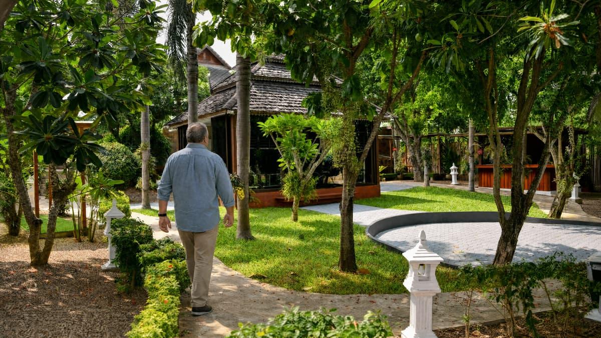 Man walking a sunlit Jintara garden path, continuing his mood stabiliser regimen through treatment