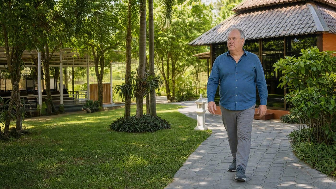 Man walking the garden path at Jintara Rehab in Chiang Mai, where burnout and substance use are treated together