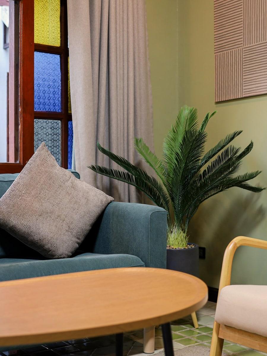 Warm residential lounge with stained-glass windows at Jintara Rehab in Chiang Mai, Thailand