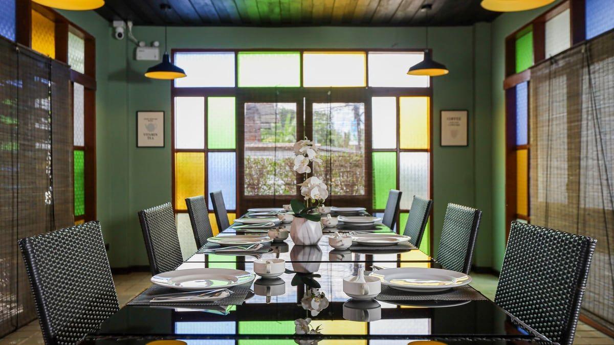 Dining room with stained-glass windows and a set table at Jintara Rehab in Chiang Mai