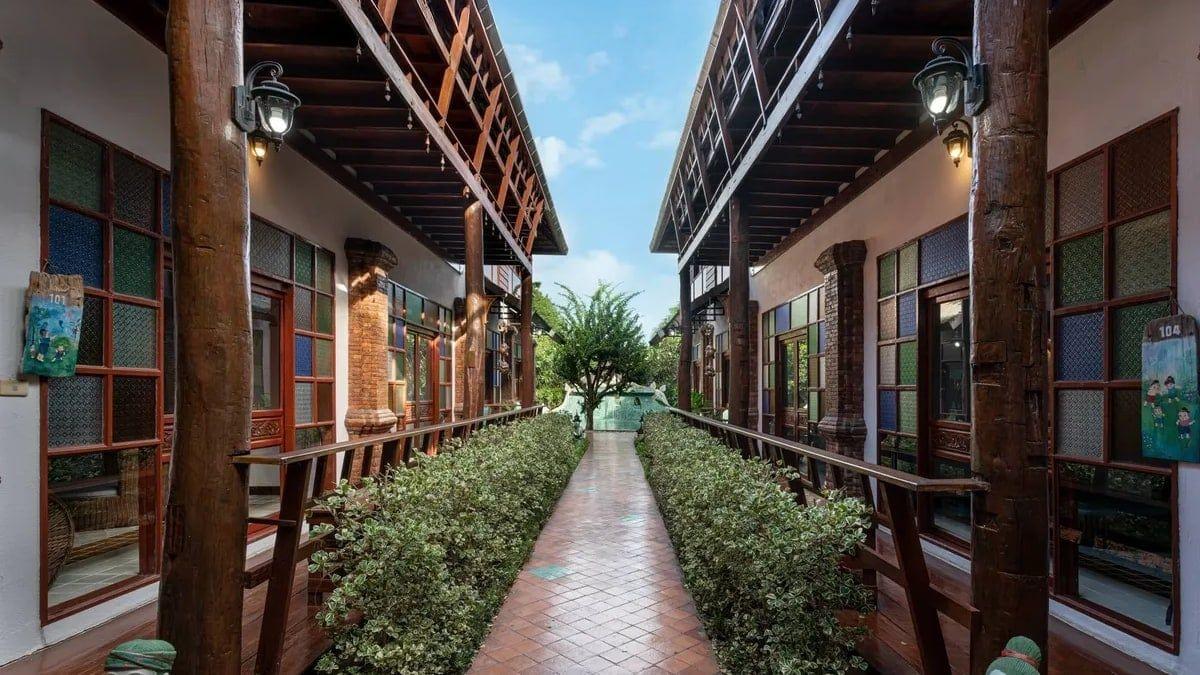 Bright covered walkway between Lanna-style buildings at Jintara Rehab in Chiang Mai