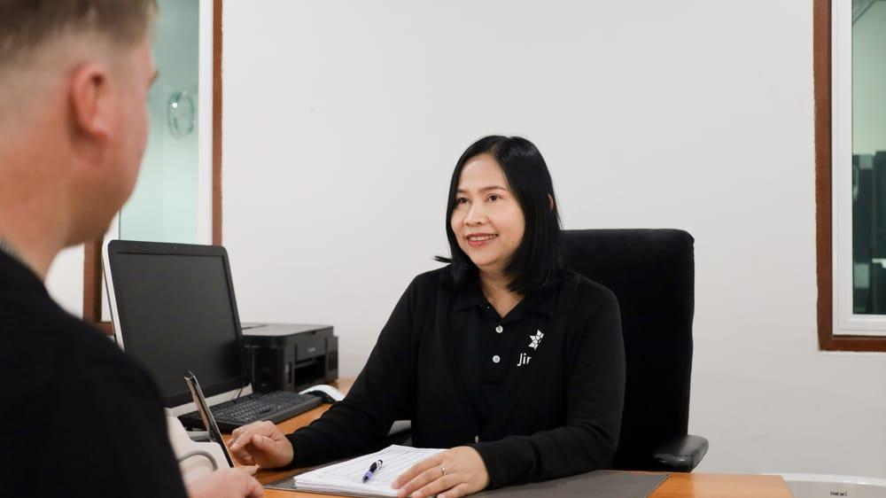 Jintara Rehab clinical staff member in consultation with client at desk in Chiang Mai treatment centre