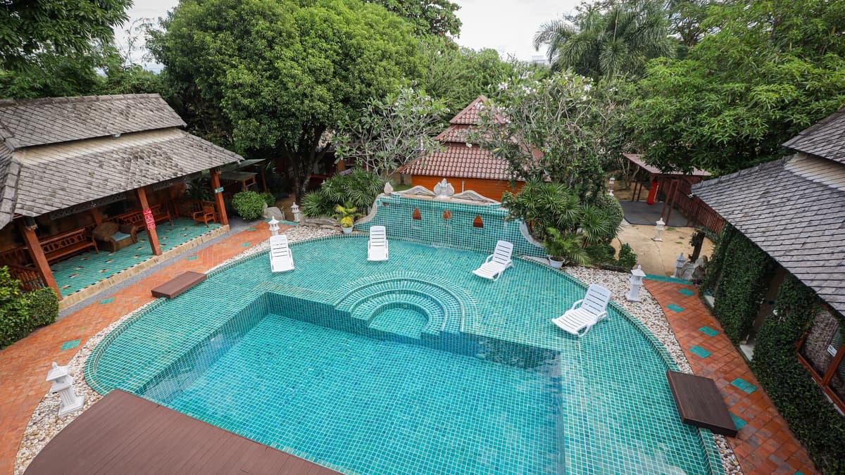 A teal mosaic pool and tropical gardens at Jintara Rehab Chiang Mai Thailand