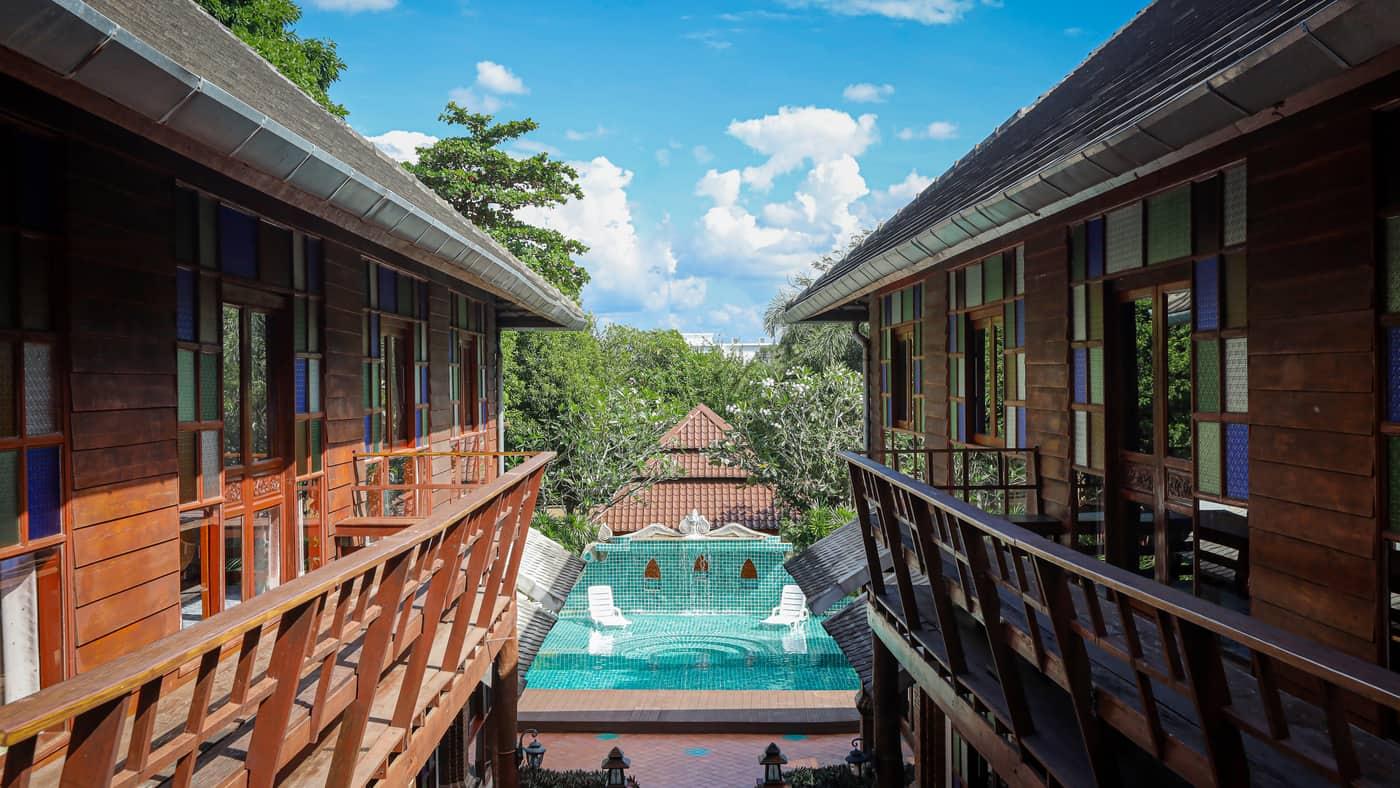 Symmetrical teak walkway and courtyard pool at Jintara Rehab Chiang Mai with lanterns