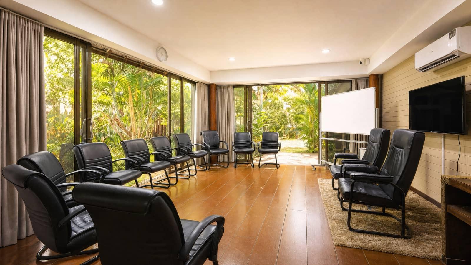 Circle of leather chairs in group therapy room at Jintara Rehab with garden through glass doors