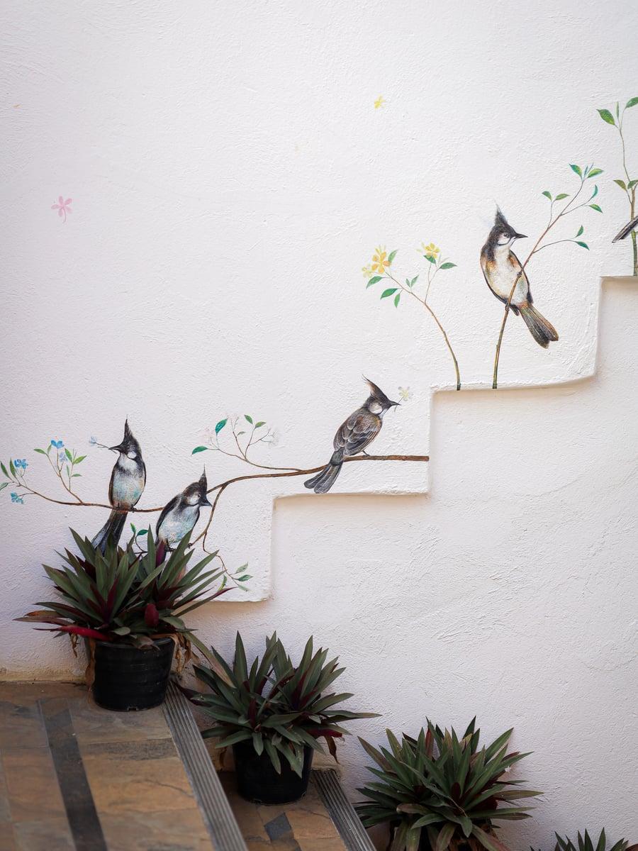 Hand-painted bird mural on entrance staircase at Jintara Rehab Chiang Mai heroin addiction treatment centre