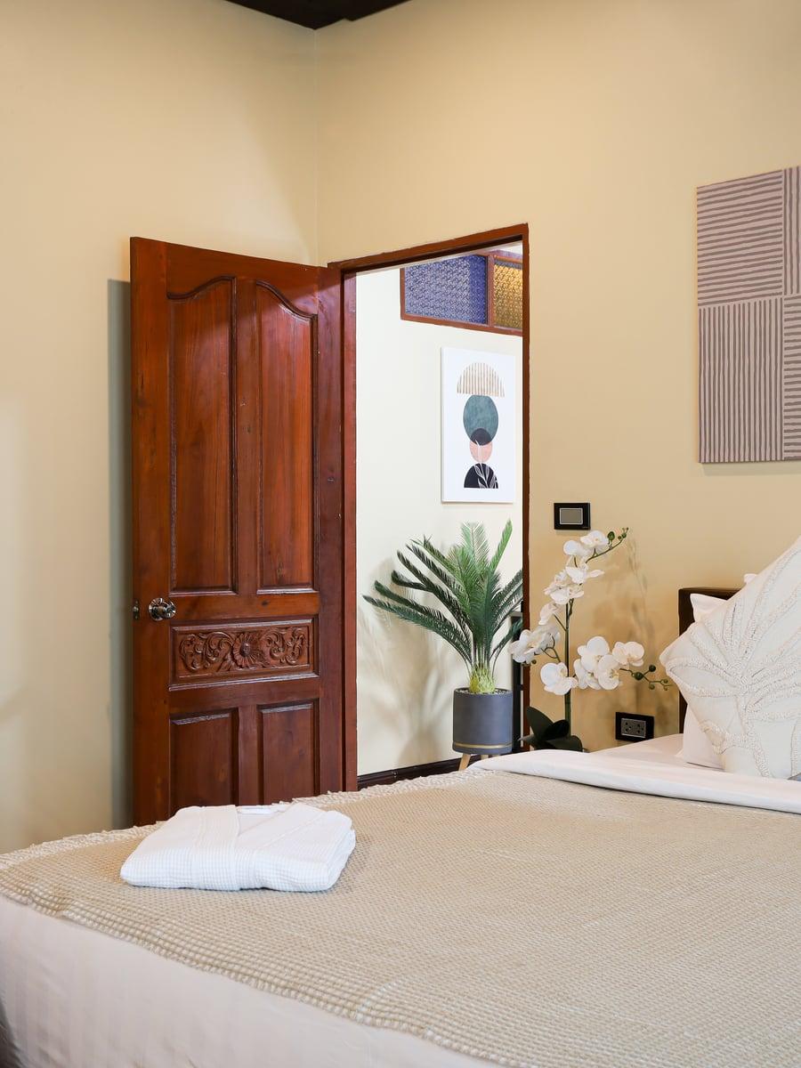 Private warm-toned bedroom suite with open doorway at Jintara Rehab Chiang Mai heroin recovery