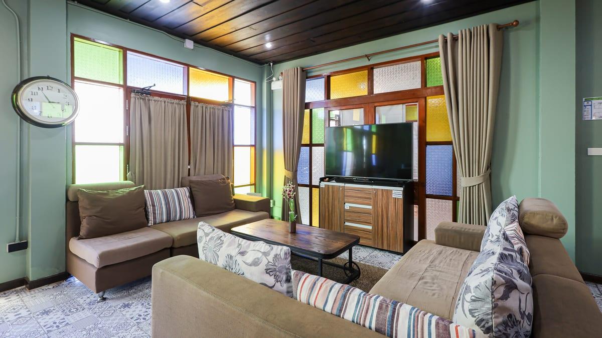 Lounge with stained glass windows, sofas and patterned floor tiles at a Chiang Mai rehab