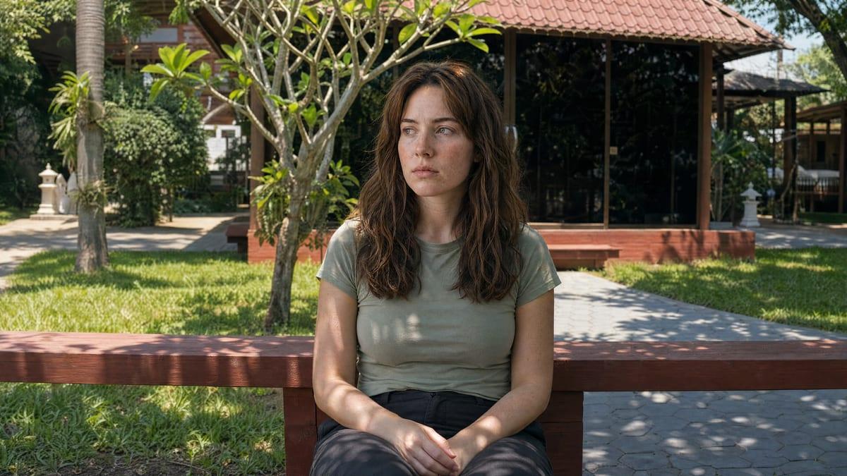Woman sitting on a timber bench outside a garden pavilion at a rehab in Chiang Mai