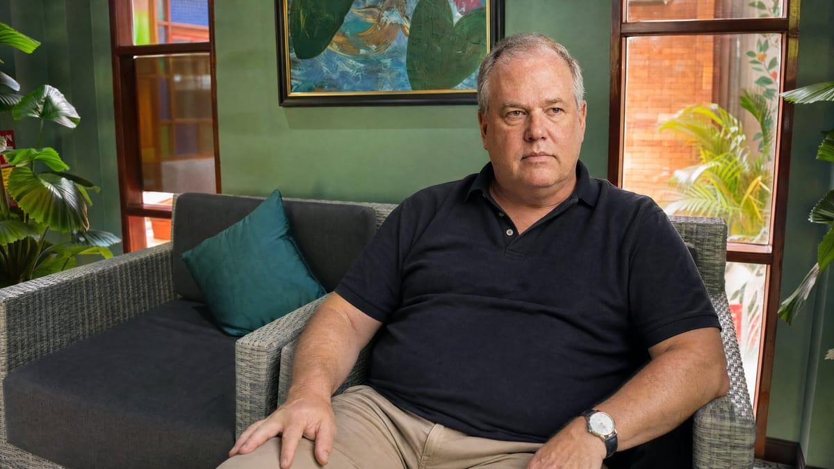 A professional man sitting quietly in a lounge armchair during recovery at Jintara Rehab in Chiang Mai