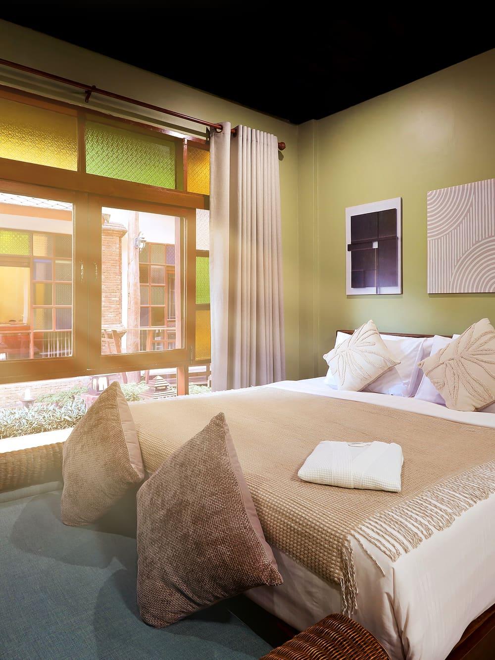 Private bedroom with warm light and a stained-glass window at Jintara Rehab Chiang Mai Thailand