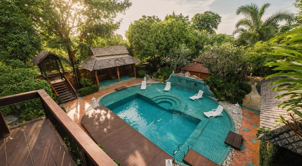 Aerial morning view of teal mosaic pool and tropical garden grounds at Jintara Rehab Chiang Mai Thailand