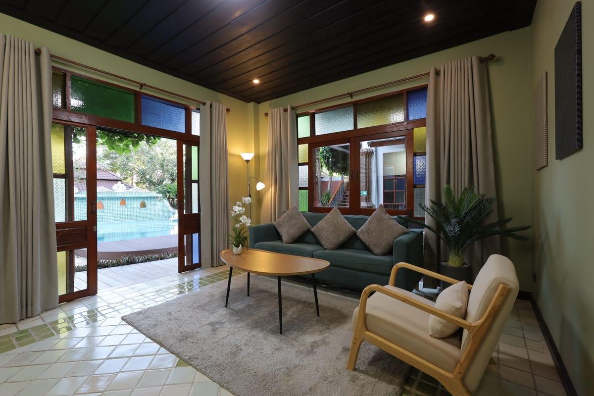 Interior lounge with teal sofa and open doors looking onto the pool at Jintara Rehab Chiang Mai Thailand