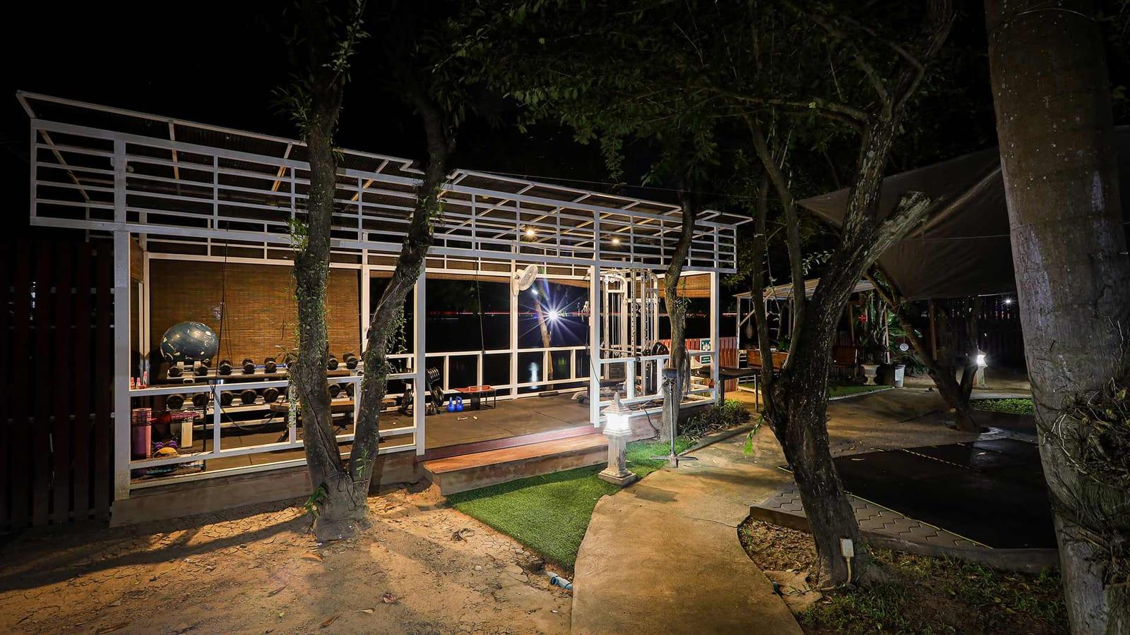 Outdoor gym with weights and pull-up frame lit at night at Jintara Rehab Thailand