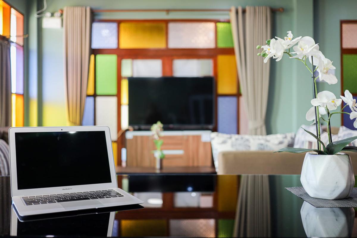Laptop on glass table in the lounge at Jintara rehabilitation facility in Chiang Mai, Thailand, with coloured stained glass windows