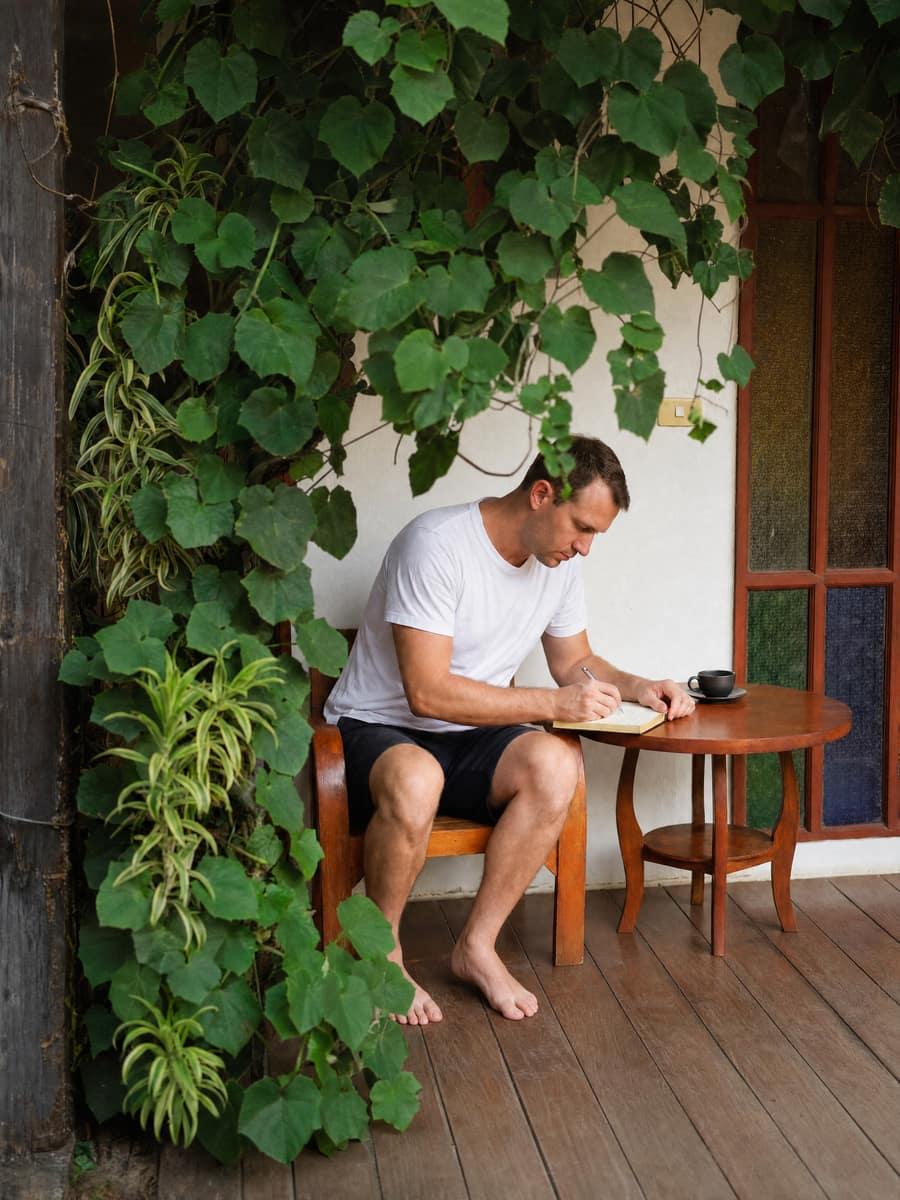 A person journaling at a quiet table with greenery during sleep restoration in Chiang Mai