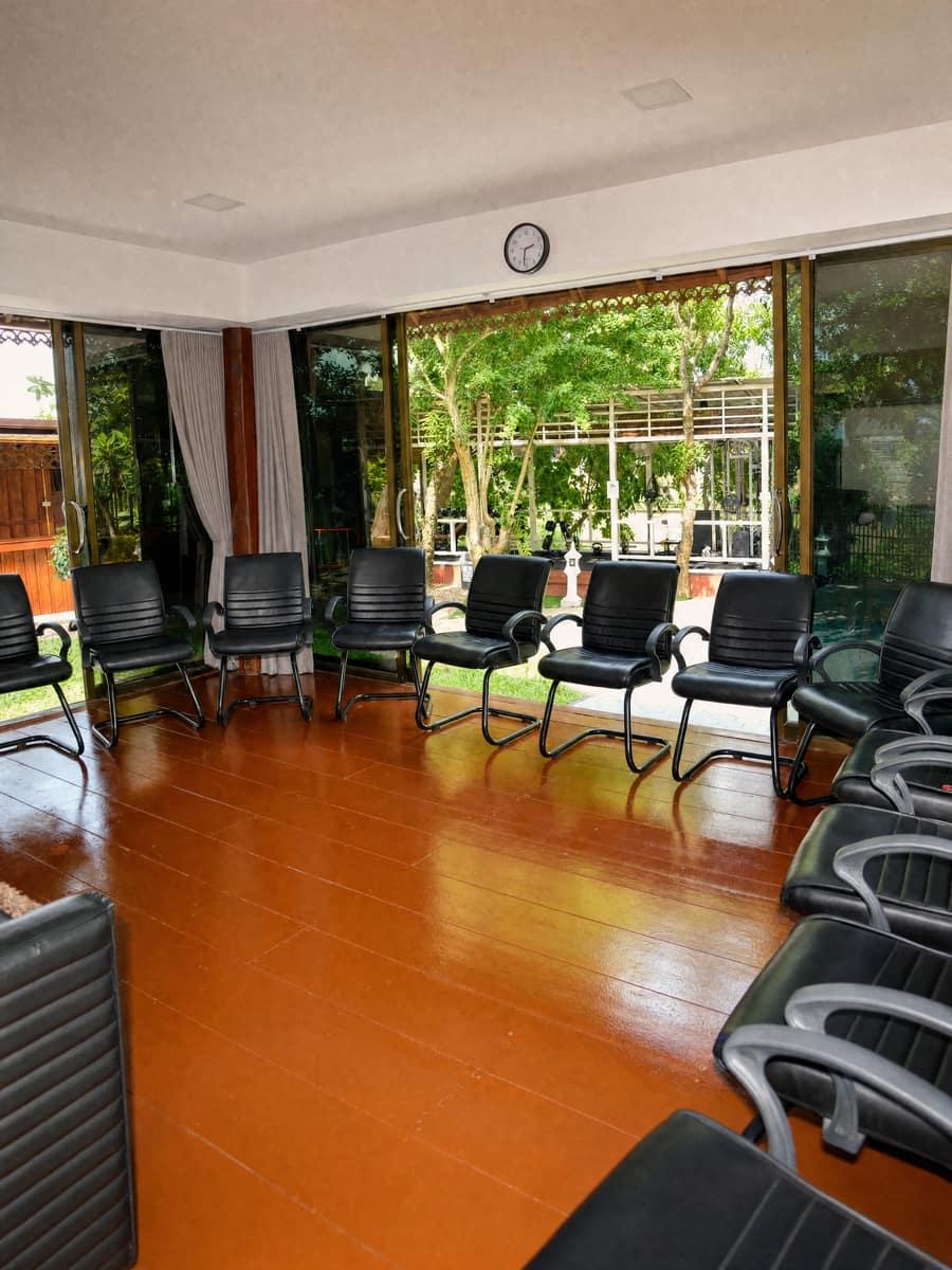Circle of chairs in a group therapy room with garden windows at a Chiang Mai rehab