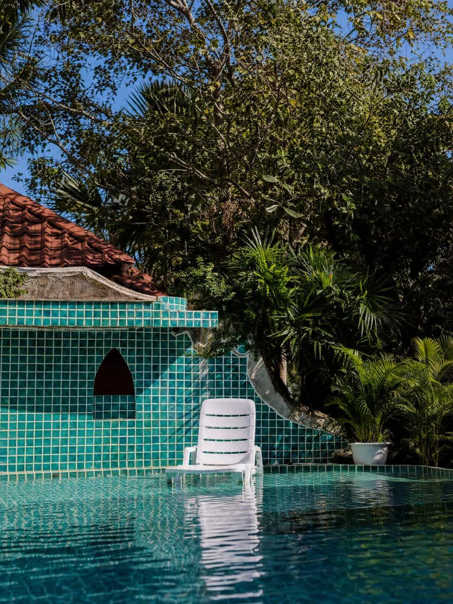 Quiet teal-tiled pool with a lounger at a sleeping pill rehab in Chiang Mai Thailand