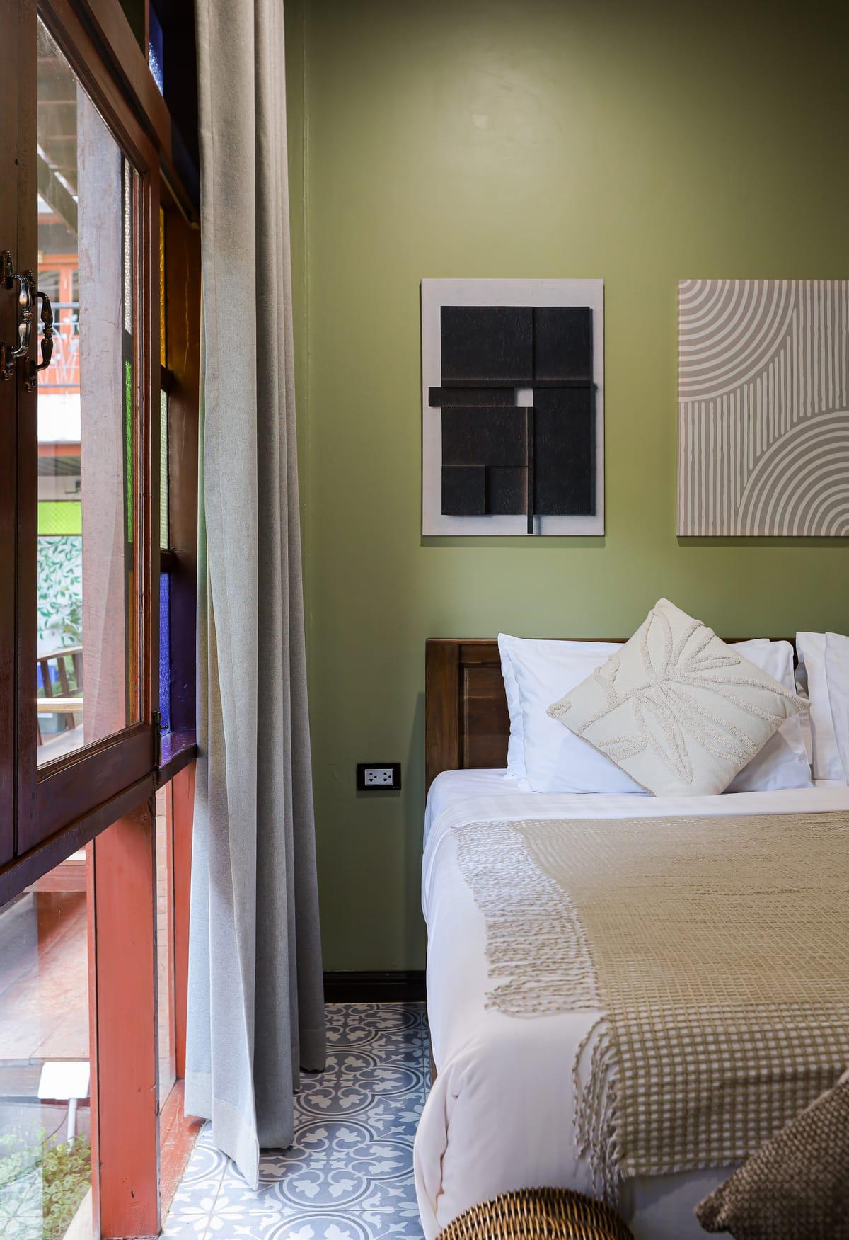 A bedroom with a double bed beside a window at Jintara Rehab in Chiang Mai