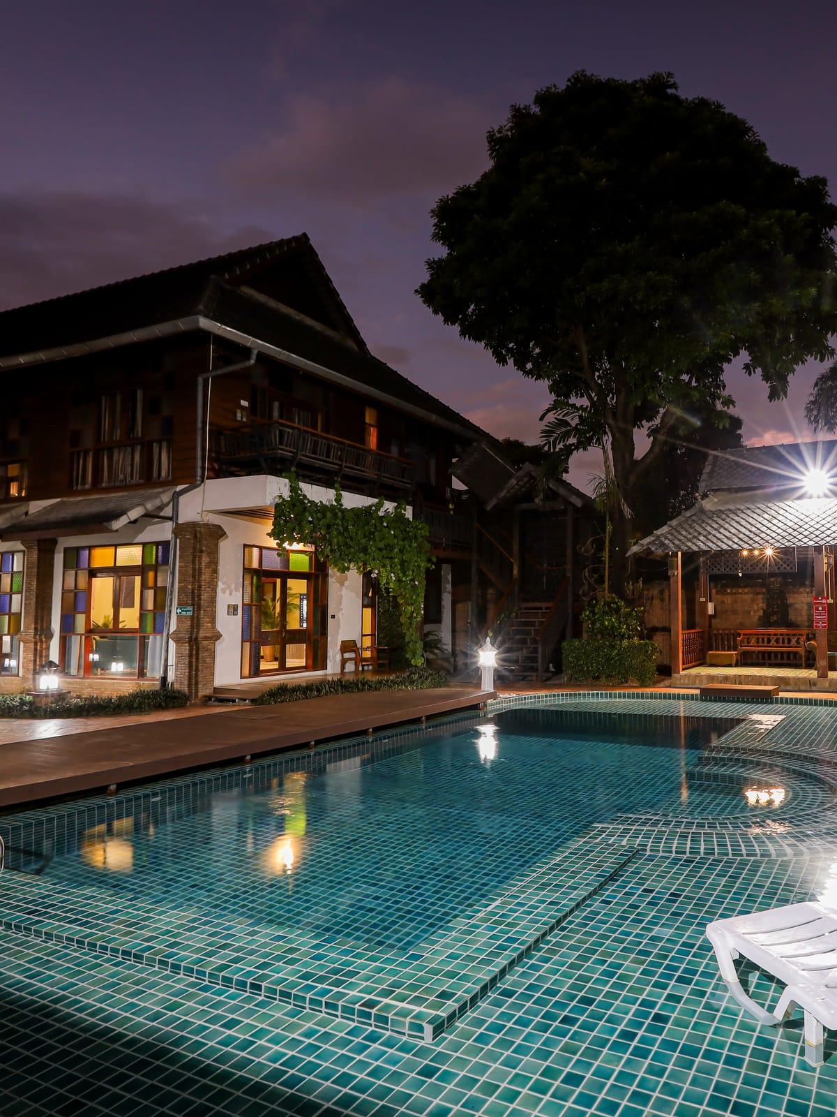 The pool and teak buildings at dusk at Jintara Rehab in Chiang Mai