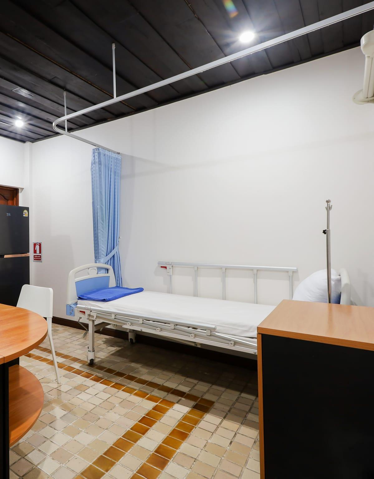 The medical room with a bed and an IV stand at Jintara Rehab in Chiang Mai