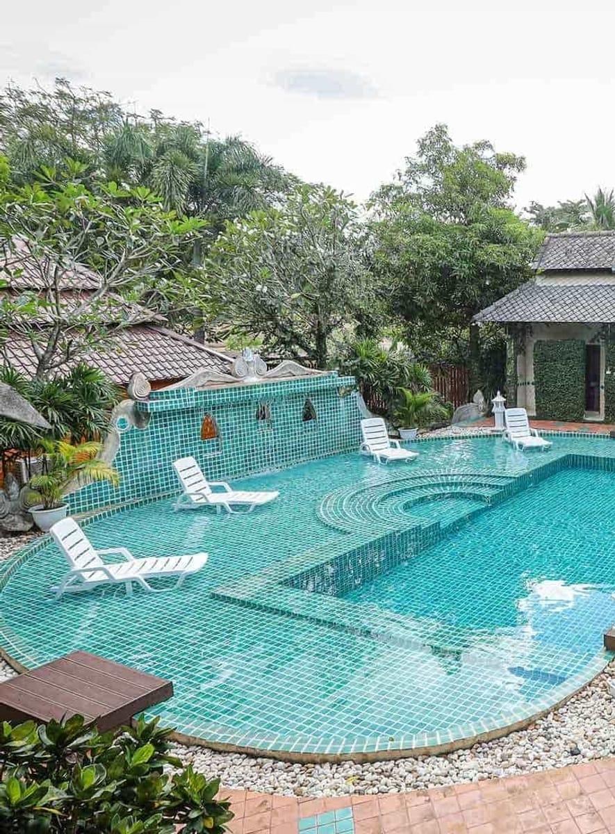 Turquoise mosaic swimming pool with loungers at Jintara Rehab Chiang Mai