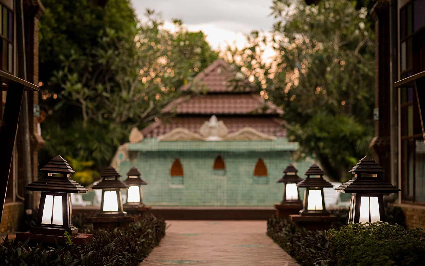 Lantern-lined pathway leading to the pool pavilion at dusk, Jintara Rehab Chiang Mai